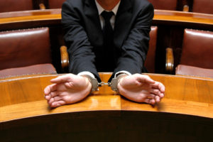 A man is handcuffed in court for his crimes.